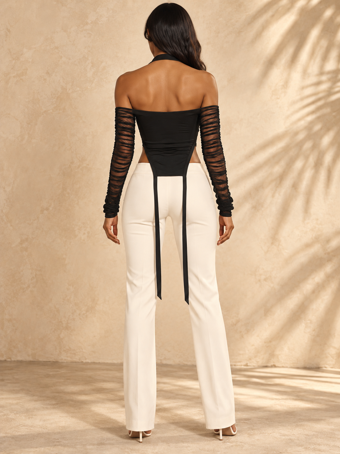 Black cold-shoulder mesh zip top on model — back view